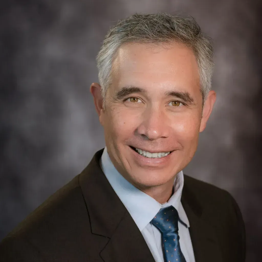 A man in a suit and tie is smiling for the camera.