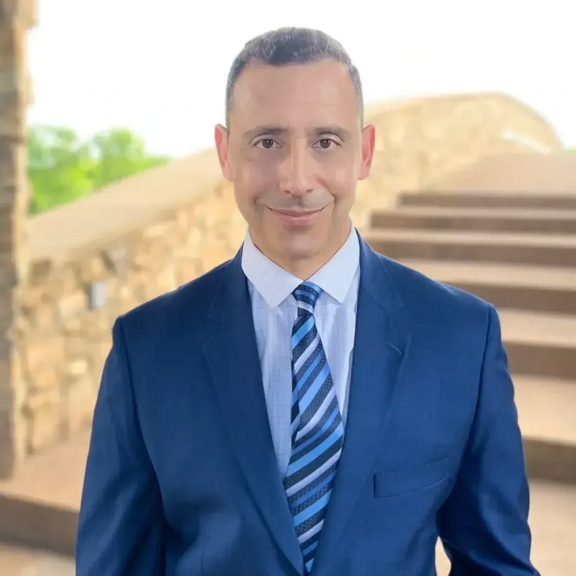 A man in a suit and tie is smiling for the camera.