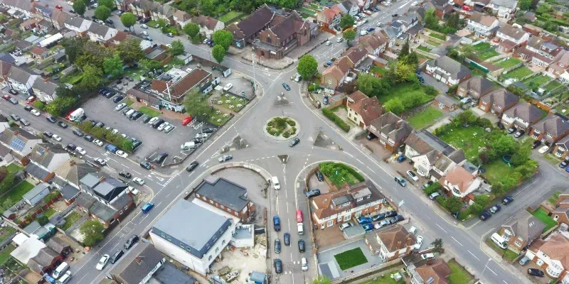 An aerial view of a residential area with a roundabout in the middle.