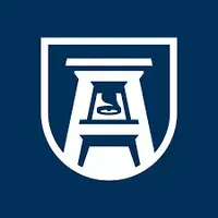 A white stool in a shield on a blue background.