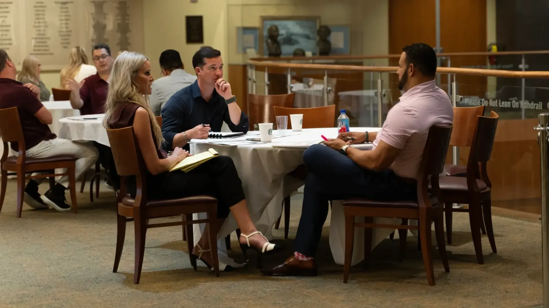 A group of people are sitting at tables in a restaurant.