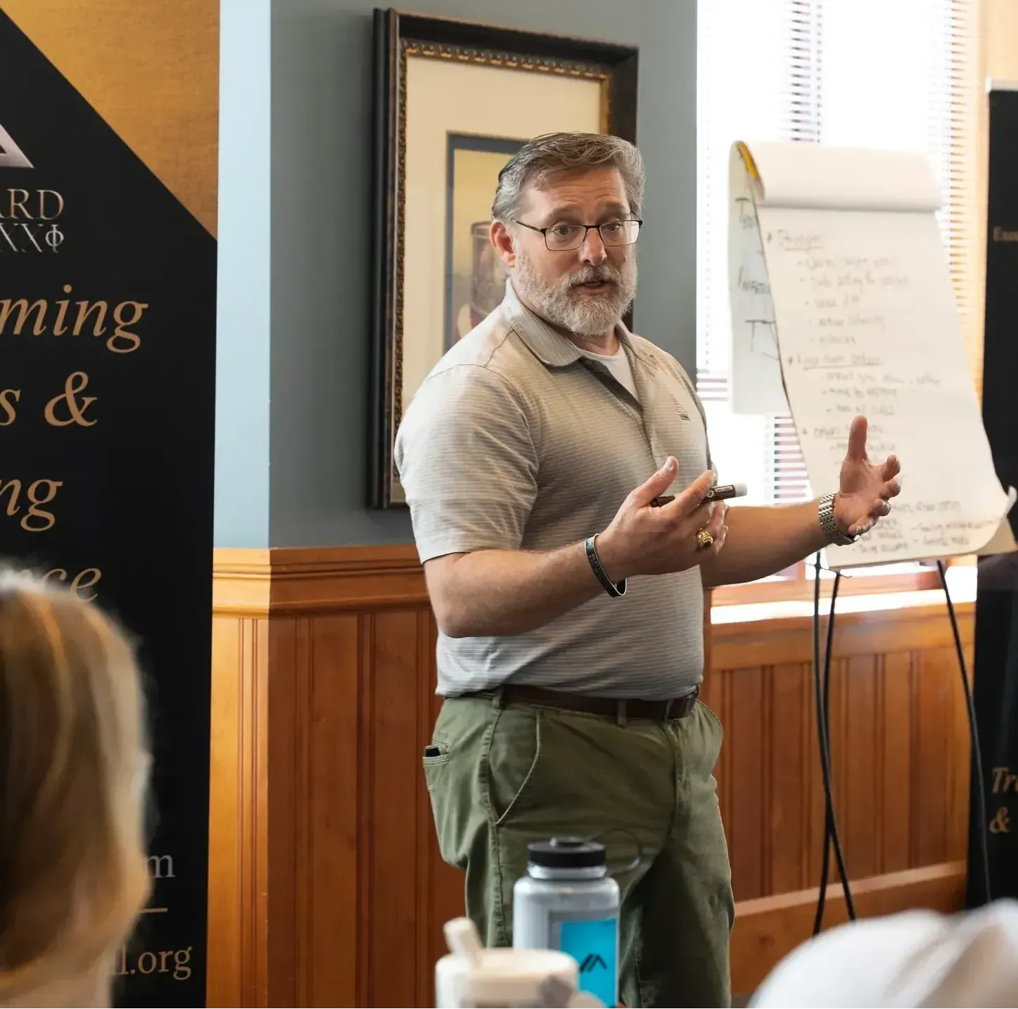 A man giving a presentation in front of a sign that says awards