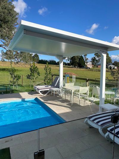 Poolside Patio With White Awning, Table and Chairs, and Lounge Chairs — Narellan Home Improvement Centre In Narellan, NSW