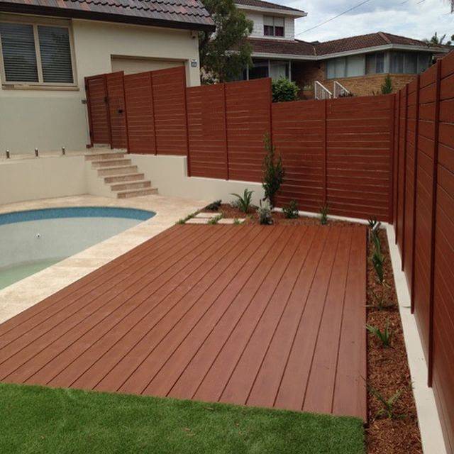 Wooden Deck Next to Pool and Fence, Bordered by Grass and Plants — Narellan Home Improvement Centre In Narellan, NSW