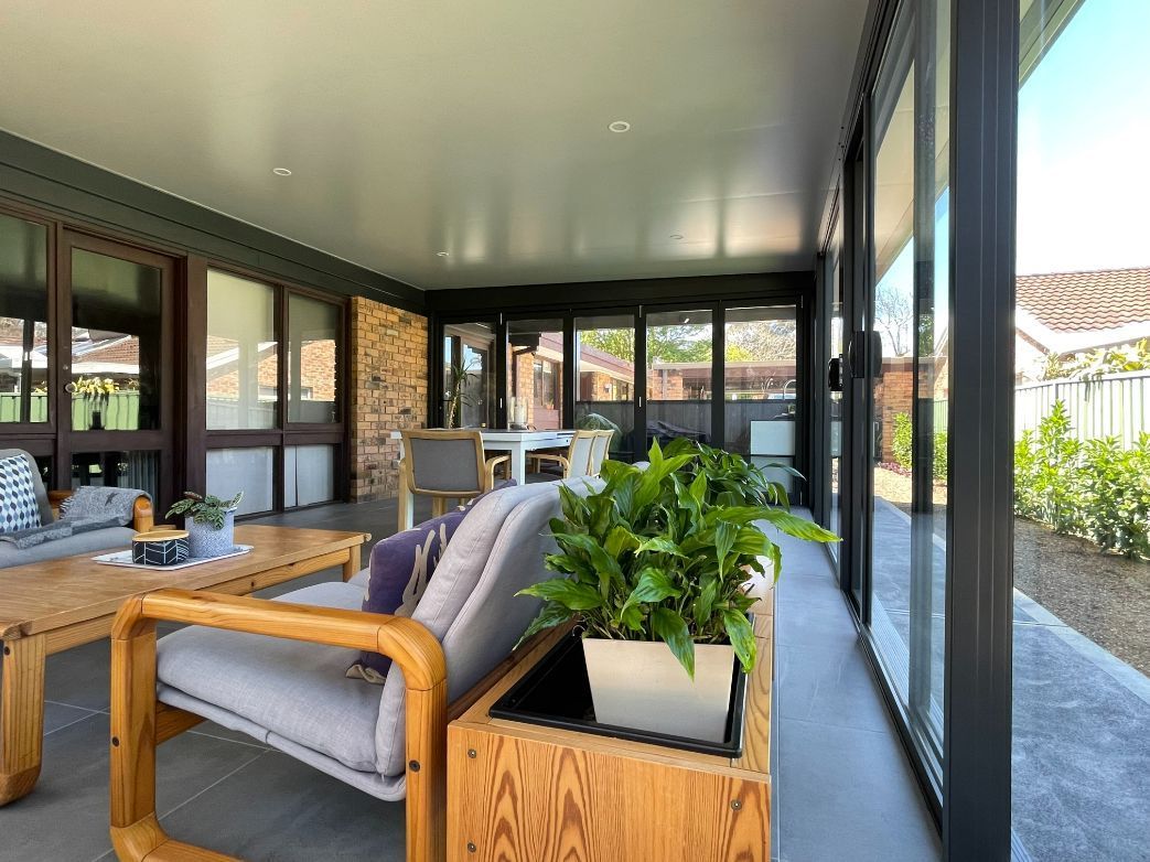 Covered Patio With Grey Furniture, Large Windows, and Plants — Narellan Home Improvement Centre In Narellan, NSW