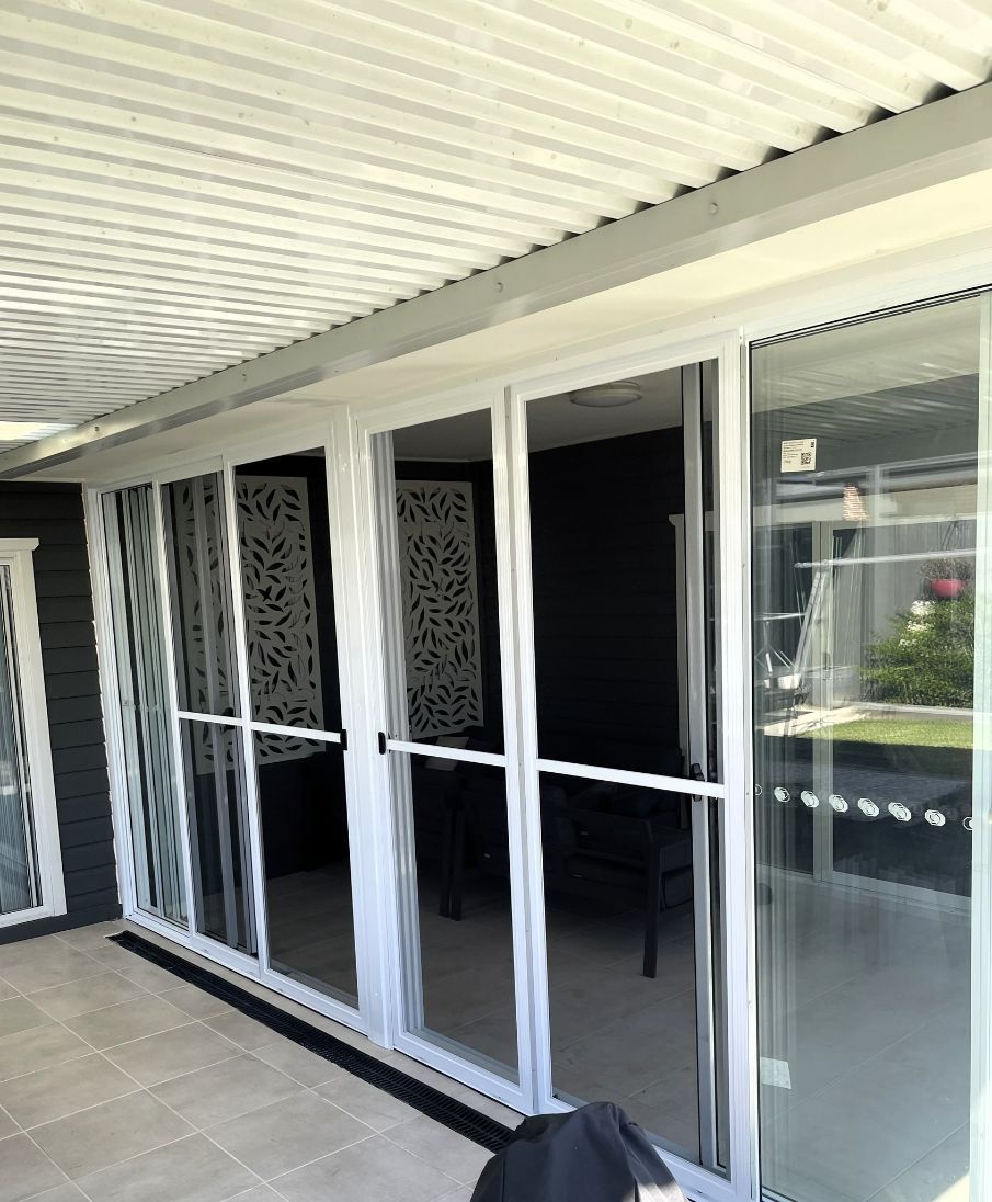 White-framed Sliding Glass Doors on a Patio With Corrugated Roof — Narellan Home Improvement Centre In Narellan, NSW