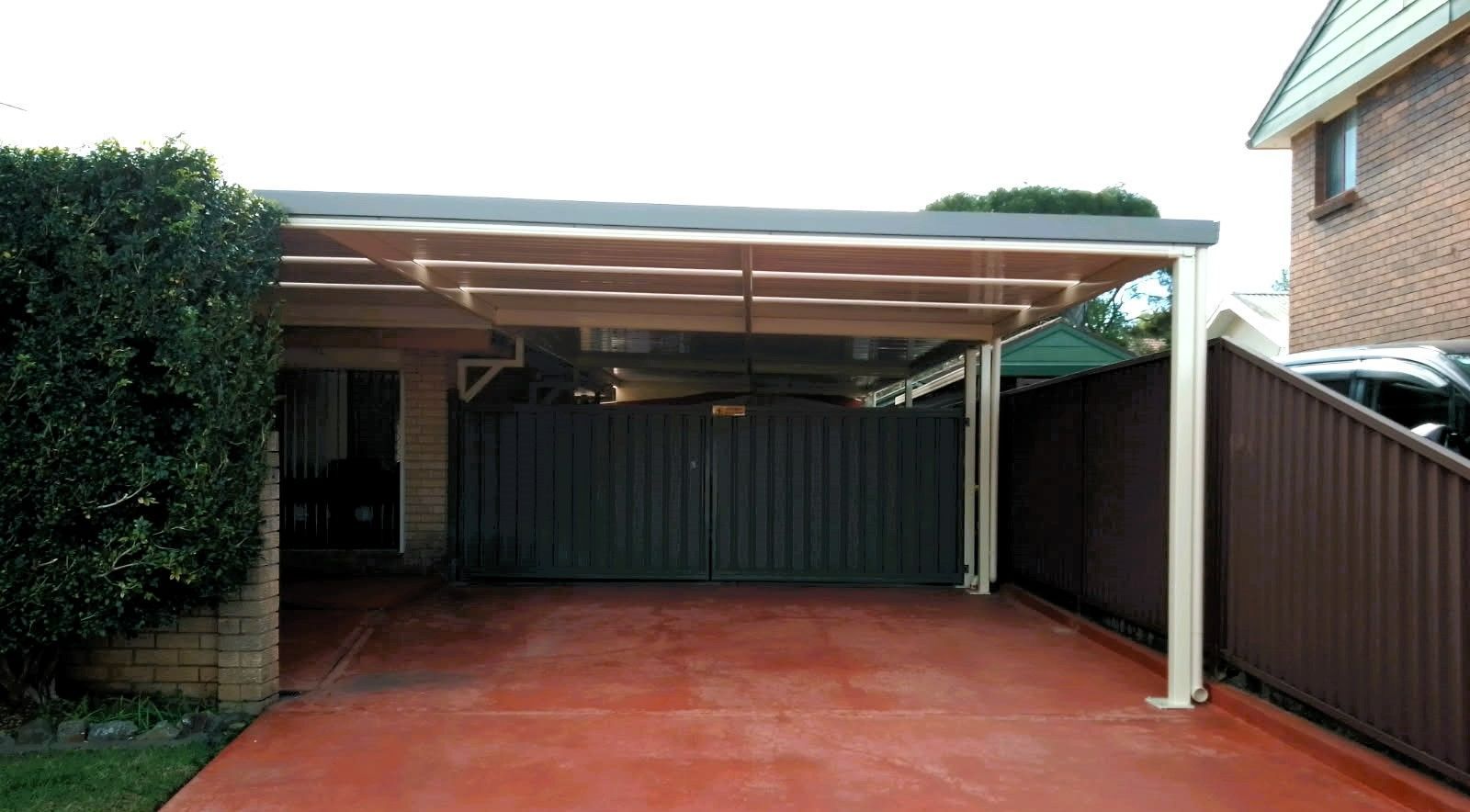 Carport With a Red Concrete Driveway, Leading to a Dark Gate — Narellan Home Improvement Centre In Southern Highlands, NSW