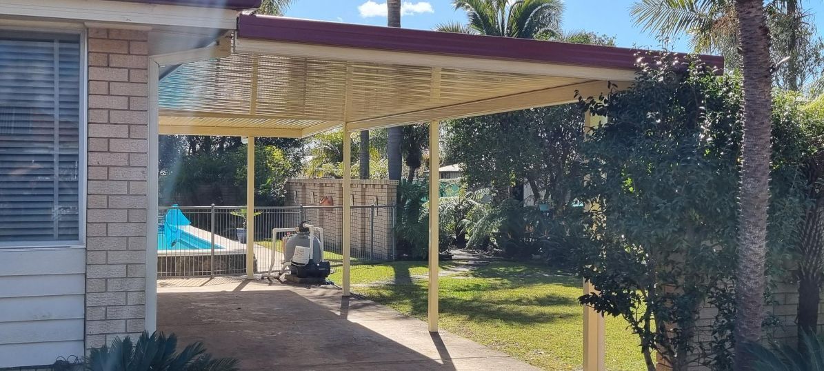 Carport Attached to a Brick Home, With a Light-colored Roof and Red Trim — Narellan Home Improvement Centre In Newcastle, NSW