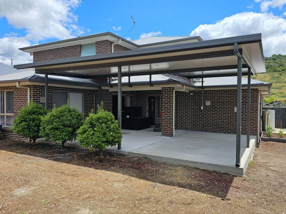 a Carport Attached to a Brick House With a Gray Roof and a Concrete Patio — Narellan Home Improvement Centre In Dubbo, NSW