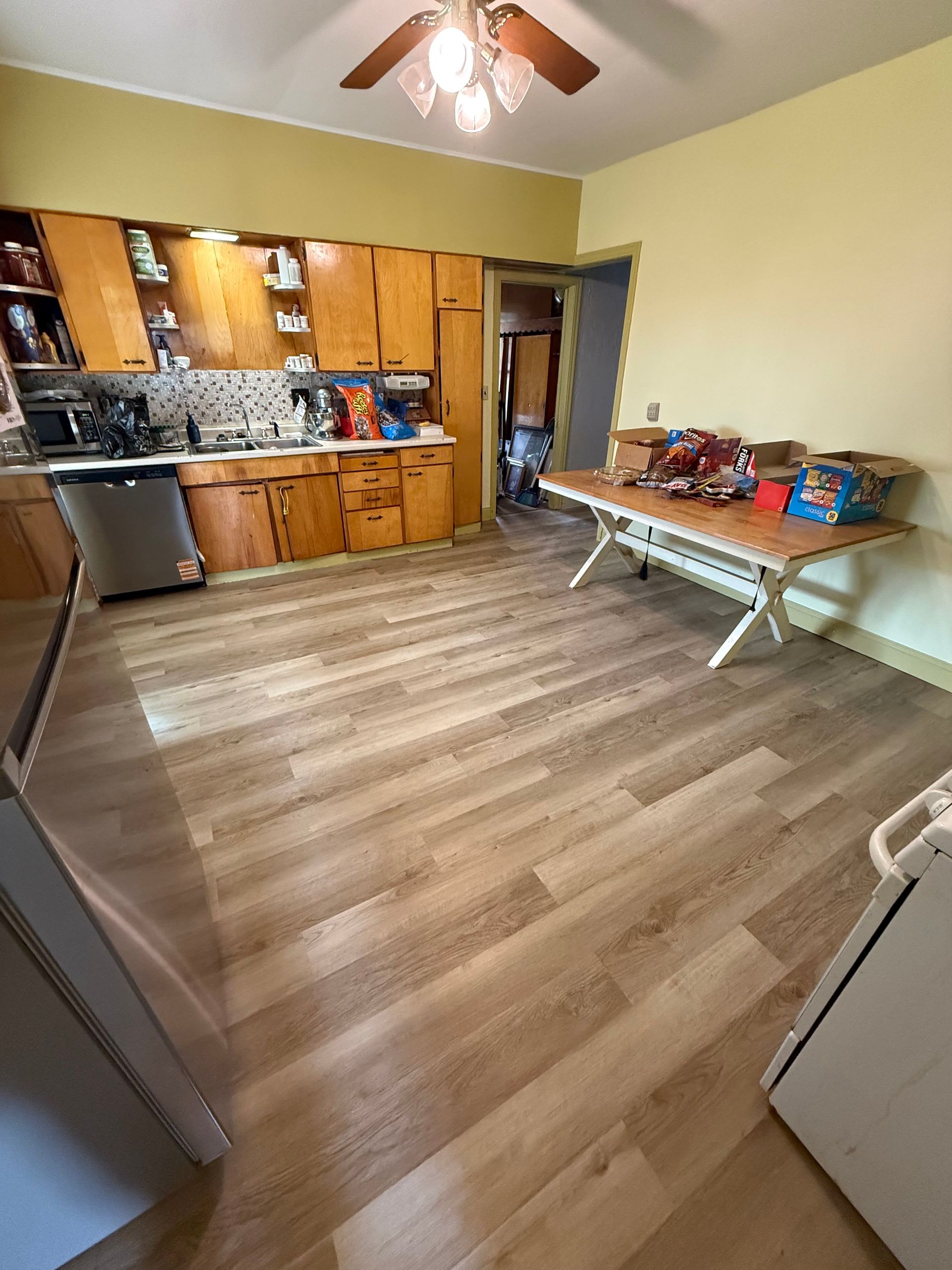 Kitchen with wood cabinets, light wood floor, and a folding table.