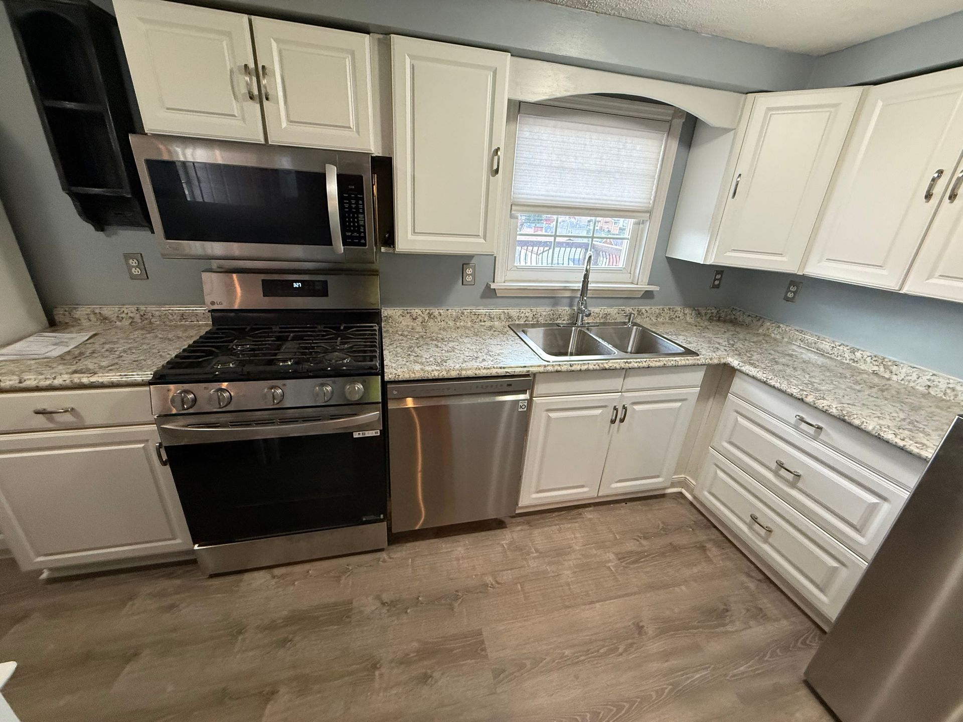 White kitchen cabinets with stainless steel appliances and light countertops.