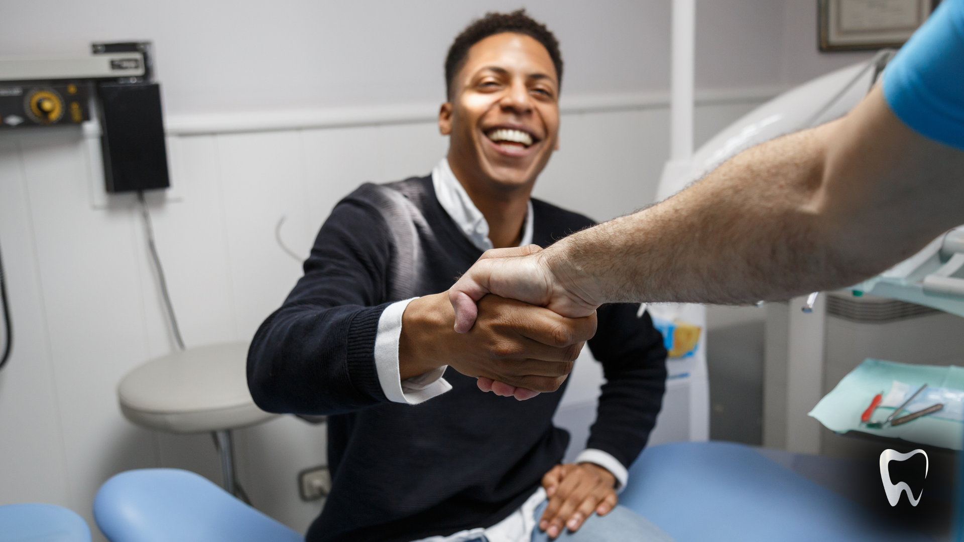 A man is shaking hands with a dentist in a dental office.