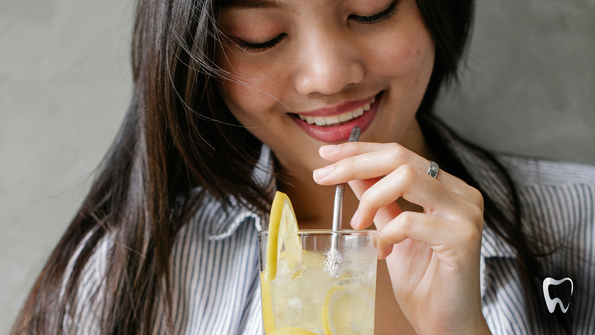 A woman is drinking a drink through a straw.