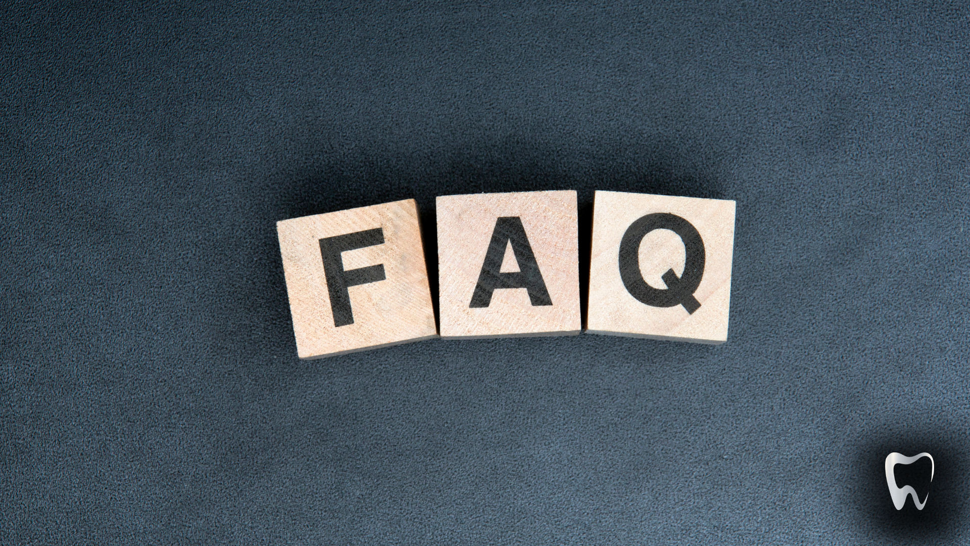 The word faq is written on wooden blocks on a black surface.