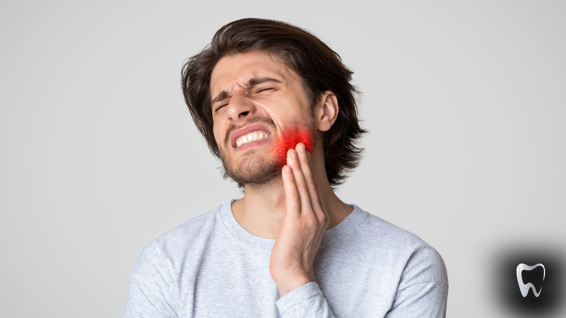 A man is holding his face in pain because of a toothache.