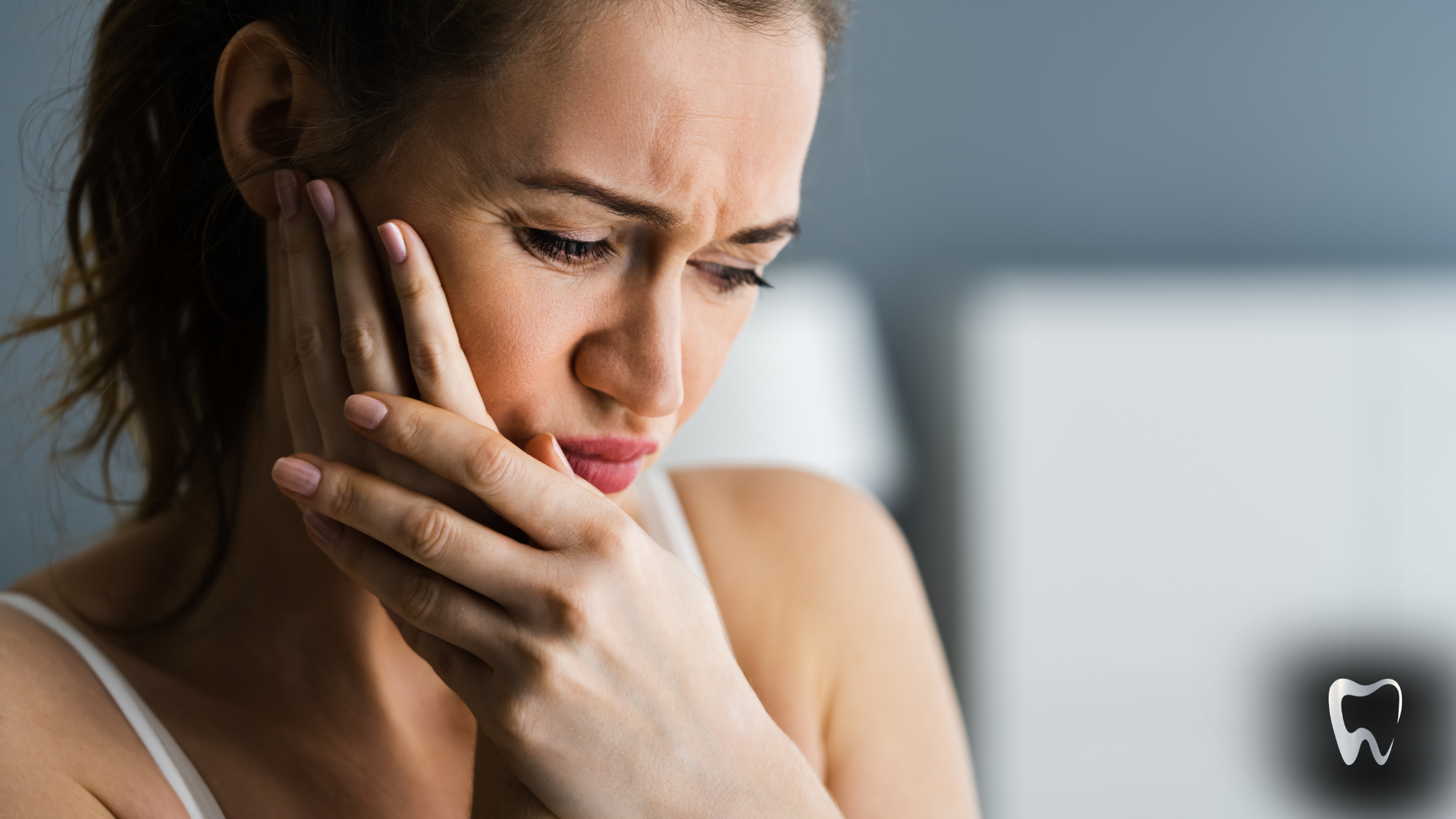 A woman is holding her face in pain because of a toothache.