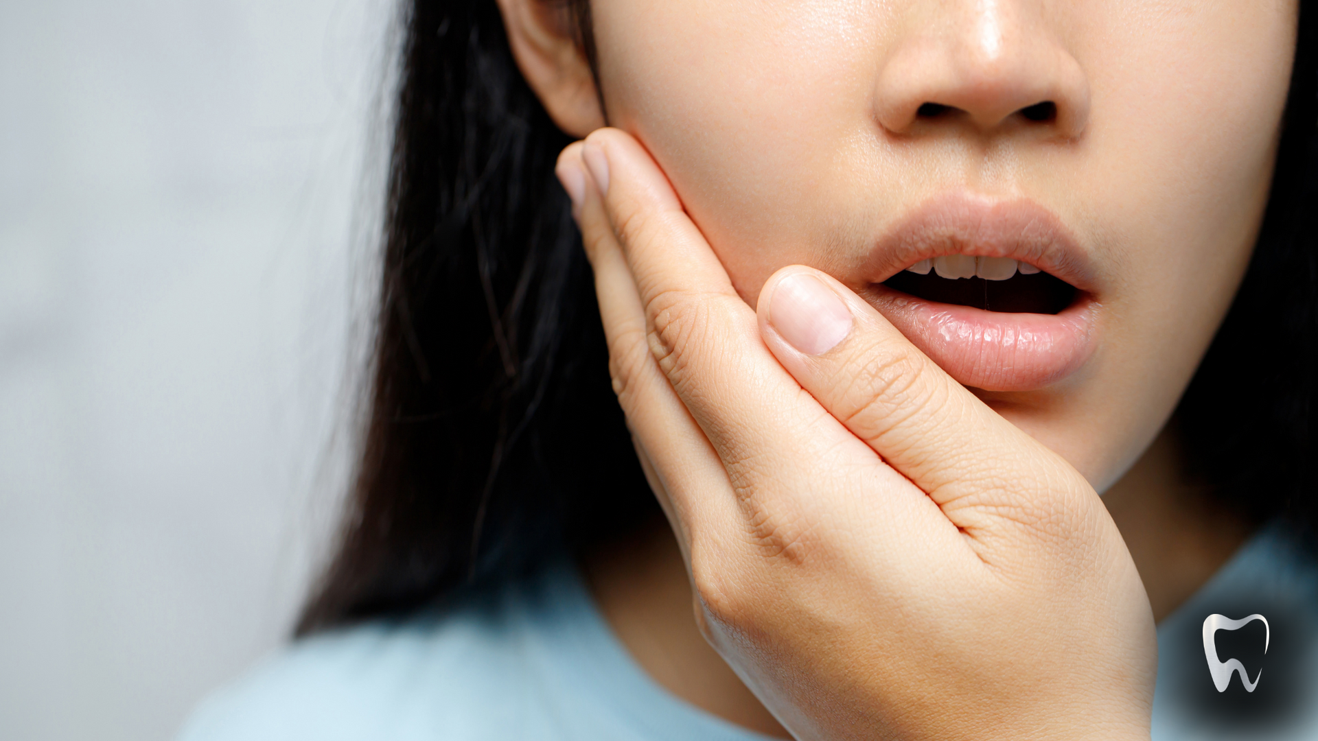 A woman is holding her face in pain because of a toothache.