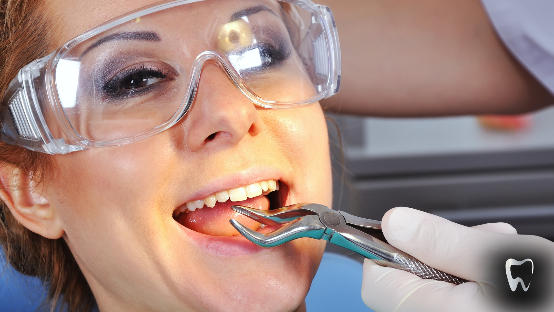Woman at dentist: mouth open, forceps to remove tooth. Dentist's hand with surgical gloves. Protective eyewear.