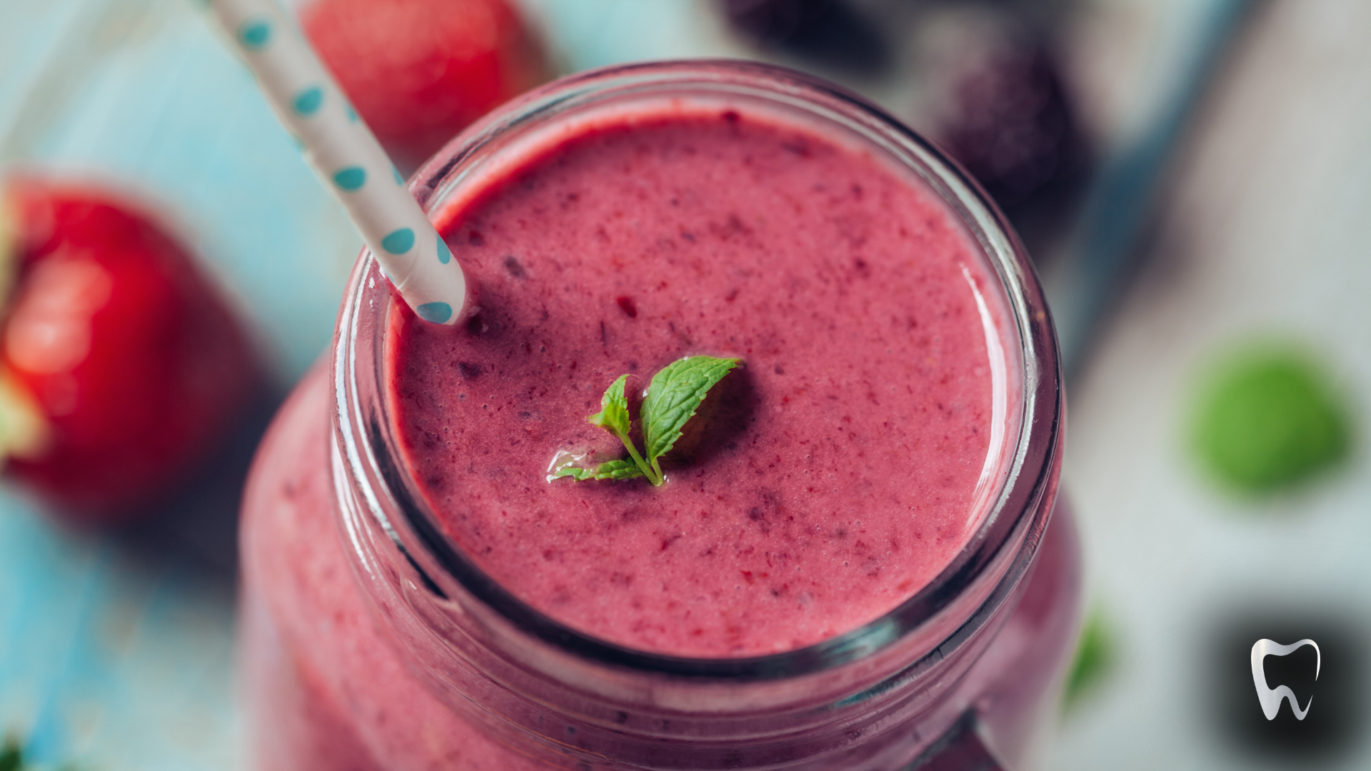 A close up of a smoothie in a mason jar with a straw.