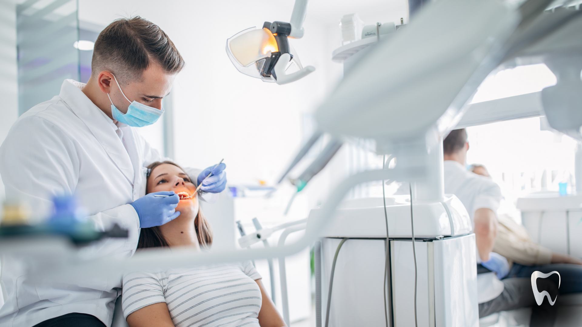 A dentist is examining a woman 's teeth in a dental office.