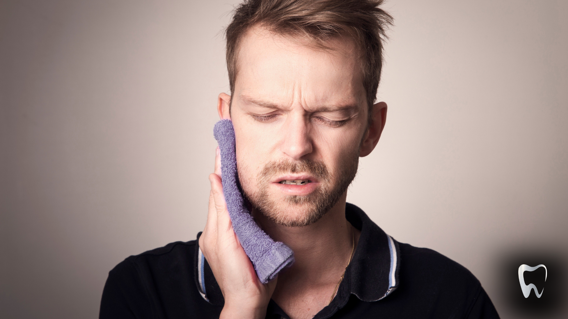 A man is holding a towel to his face because he has a toothache.