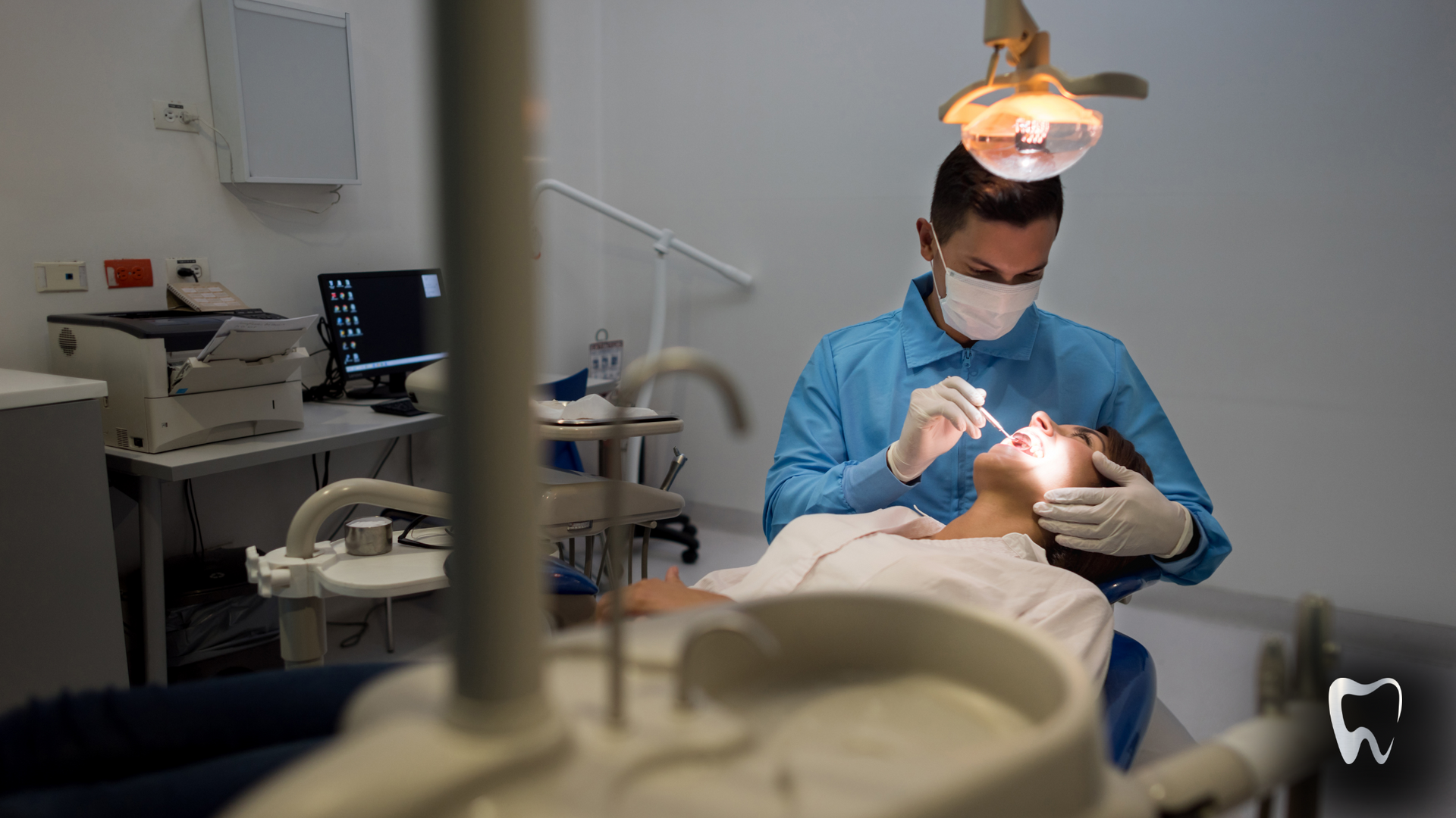 A dentist is examining a patient 's teeth in a dental office.