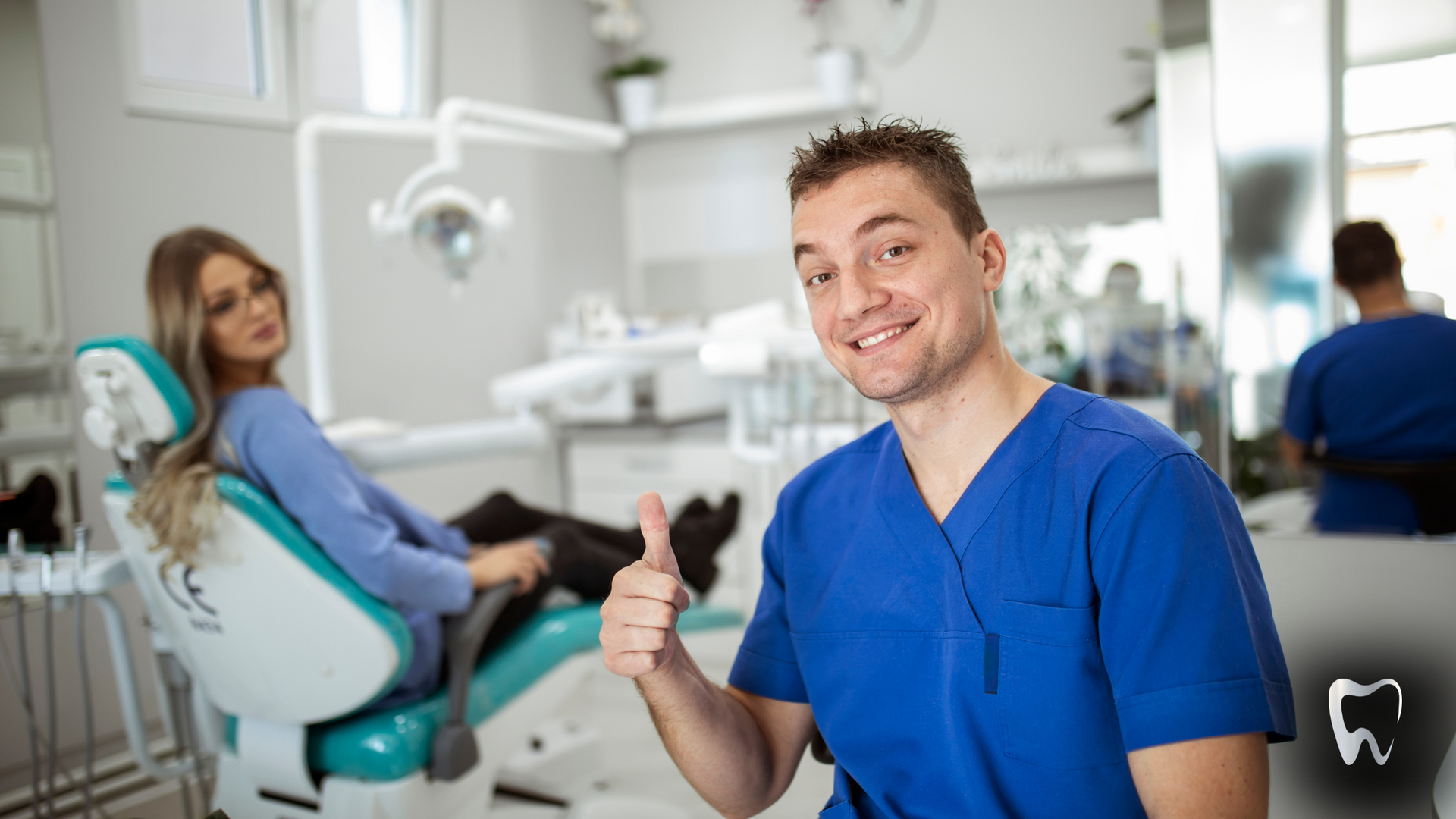 A dentist is giving a thumbs up to a patient in a dental chair.