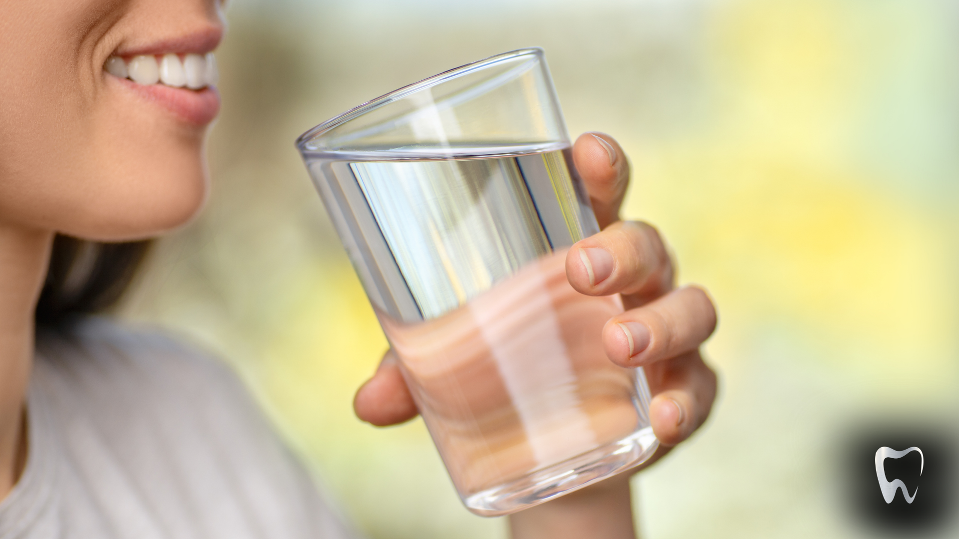 A woman is drinking a glass of water.