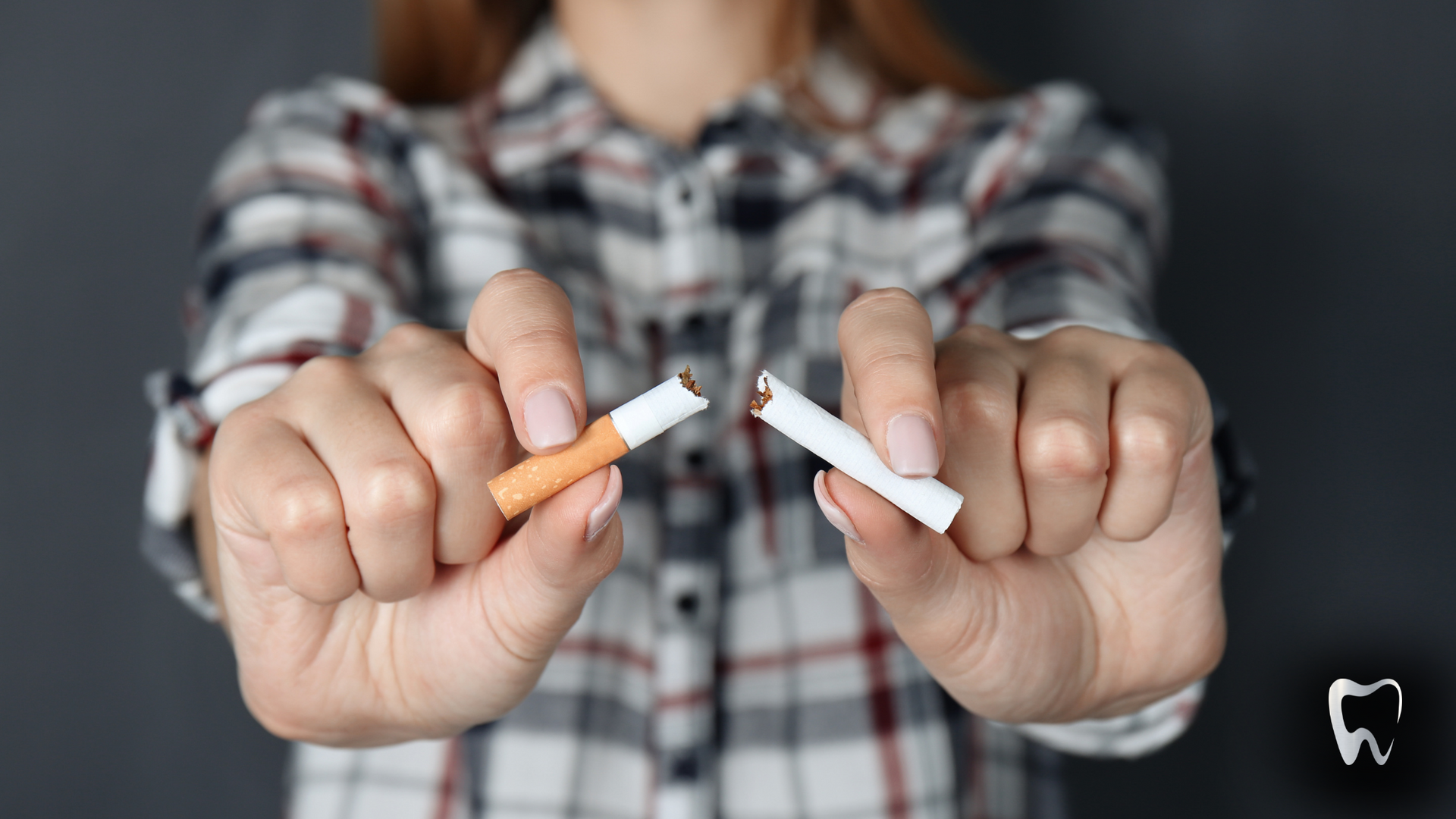 A woman is holding two broken cigarettes in her hands.