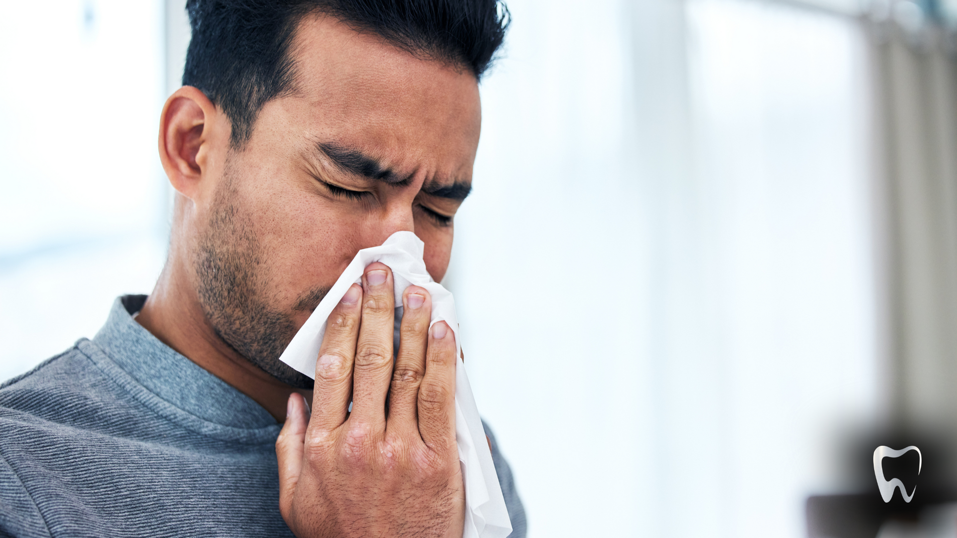 A man is blowing his nose with a napkin.