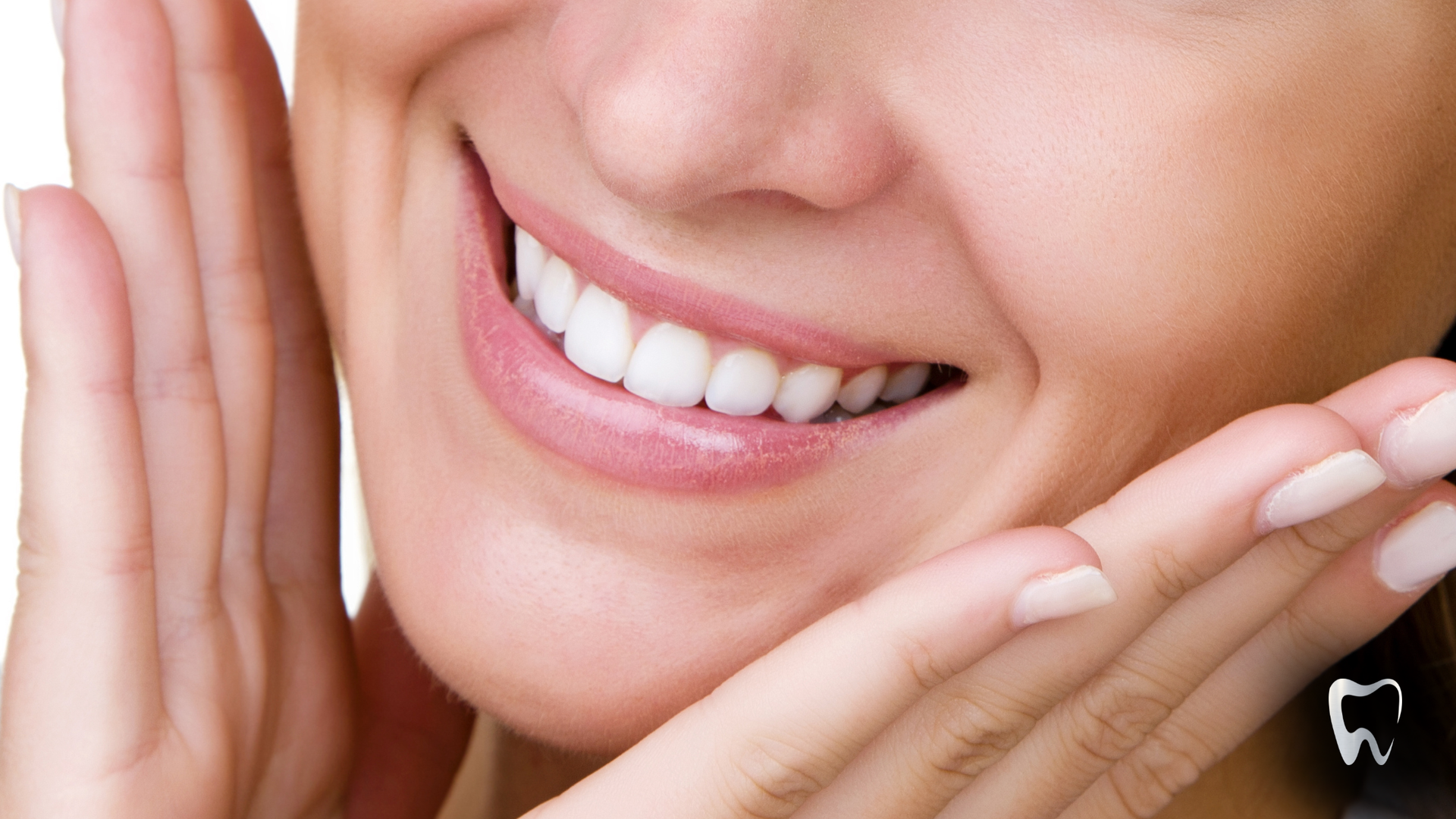 Smiling person with hands framing their face, showing white teeth.