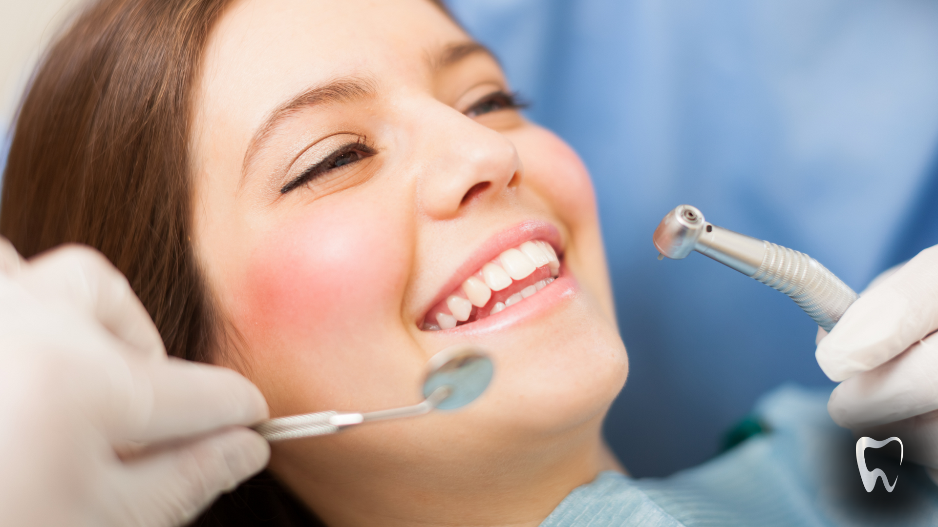 A woman is getting her teeth examined by a dentist.