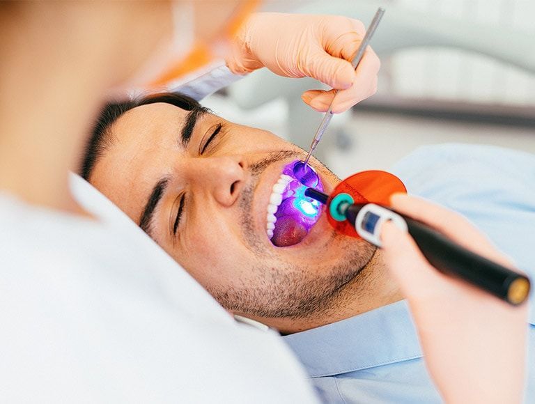 A man is getting his teeth examined by a dentist.