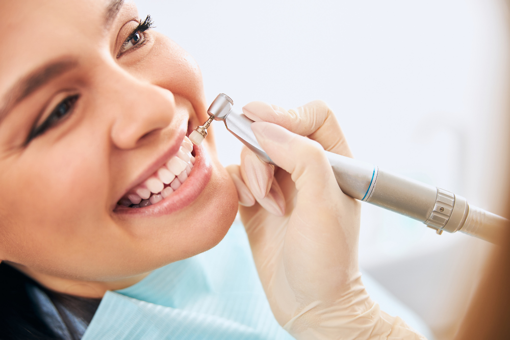 A woman is getting her teeth checked by a dentist.