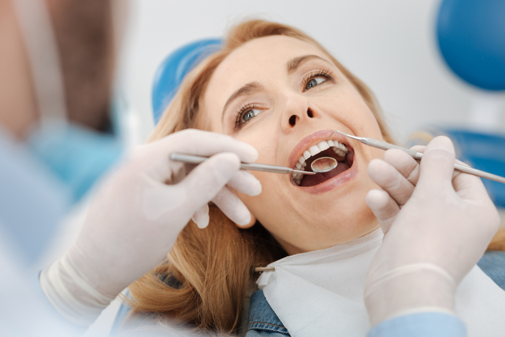 A woman is having her teeth examined by a dentist.