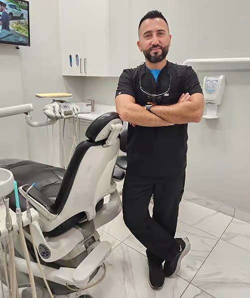 A man is standing in front of a dental chair in a dental office.