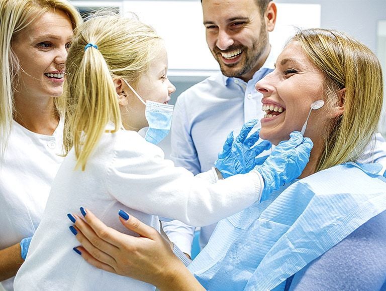 A family is having their teeth examined by a dentist in a dental office.