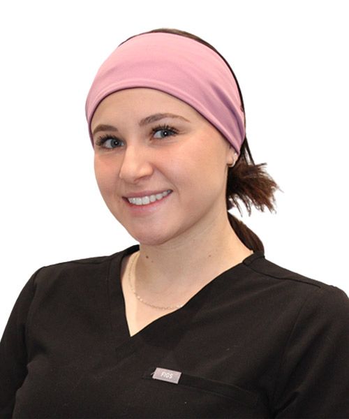 A woman wearing a pink headband and a black scrub top