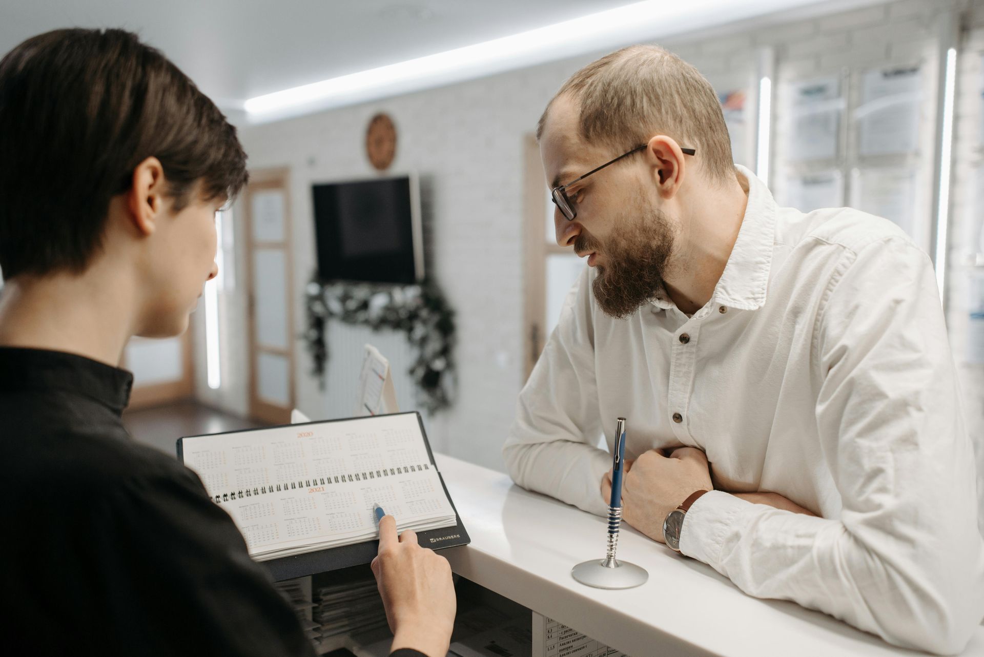 Doctor pointing to teeth model, explaining dental care.