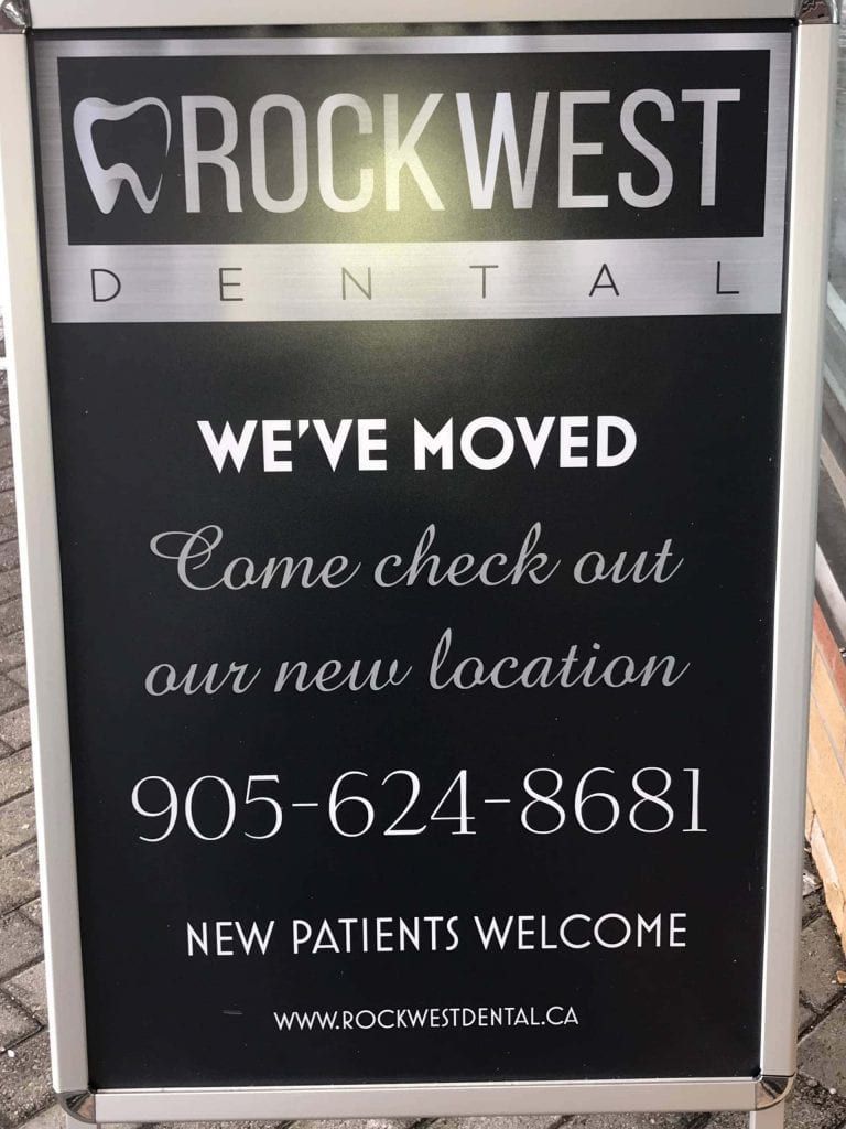 A sign for rock west dental says we 've moved come check out our new location
