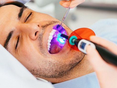 A man is getting his teeth examined by a dentist.