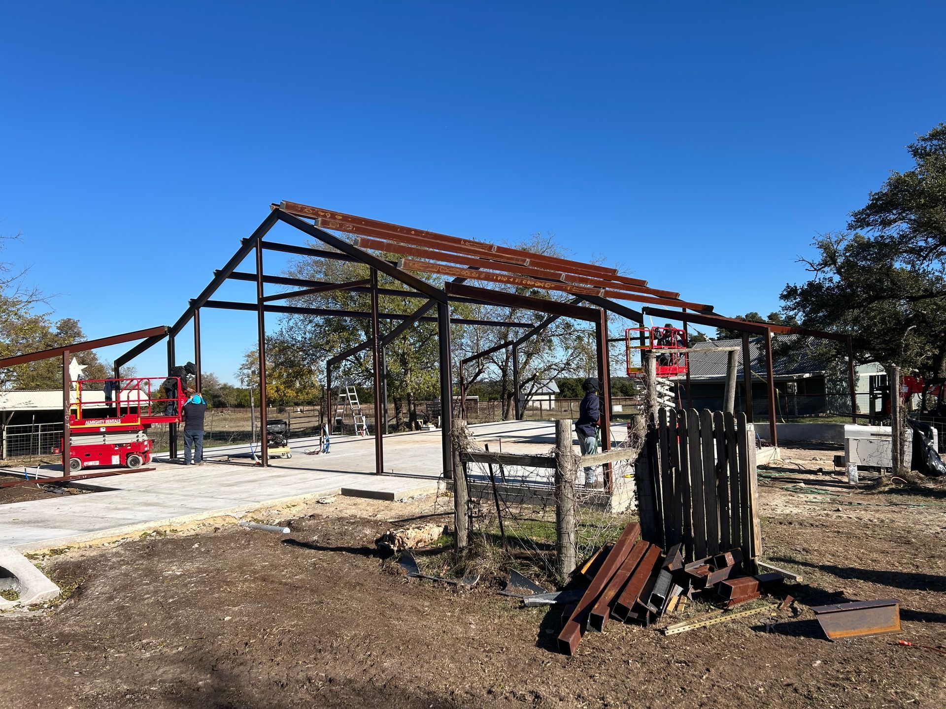Steel frame of a structure under construction outdoors on a sunny day.