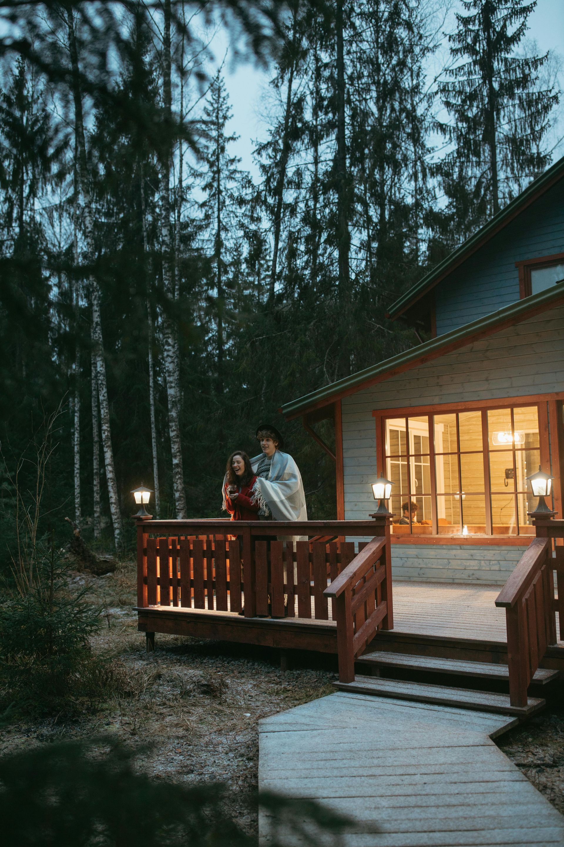 A structure with an open, exposed wooden frame and roof rafters illuminated at night in a dark, outdoor setting.