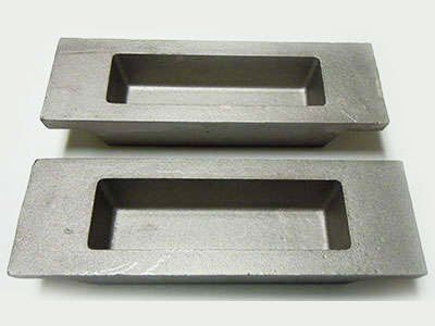 Two metal trays are sitting on top of each other on a white surface.