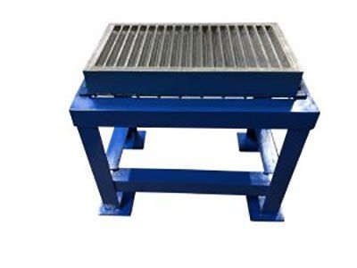 A blue metal table with a metal grate on top of it.