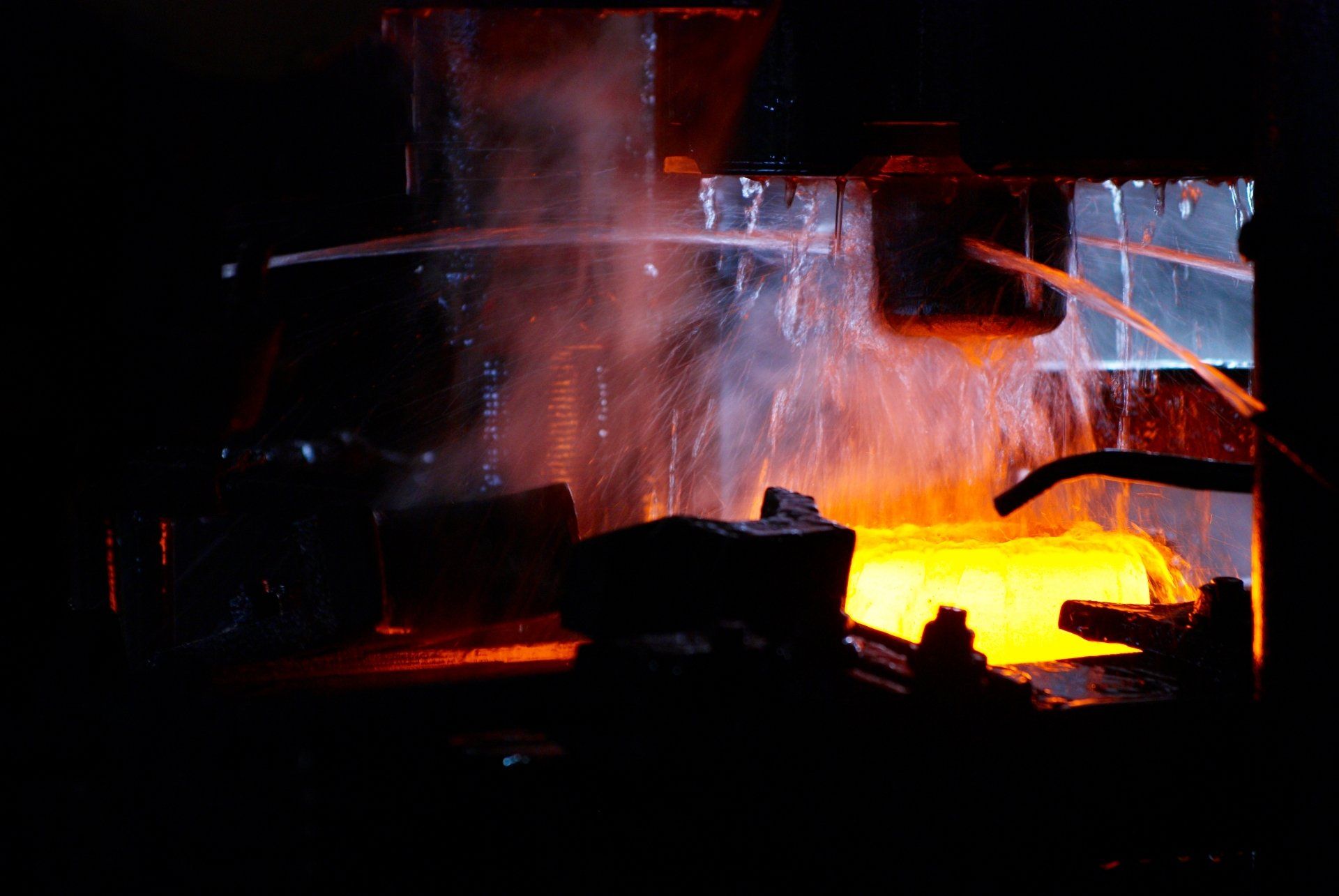 A close up of a machine making a piece of metal in a factory.