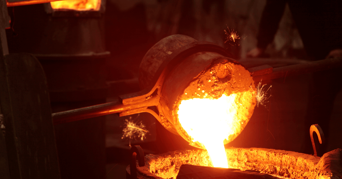 A person is pouring molten metal into a furnace.