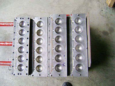 A bunch of metal balls are sitting on a table.