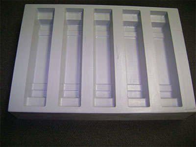 A white plastic tray with a row of holes in it