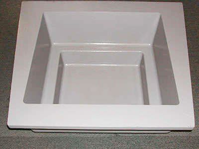 A white square bowl is sitting on top of a counter.